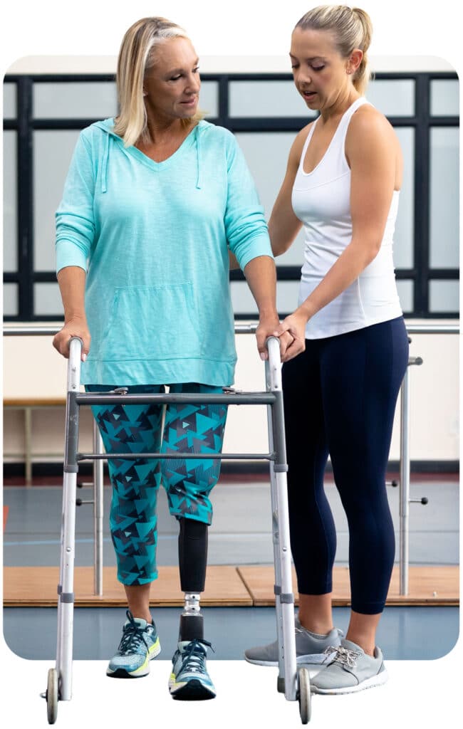 Physiotherapist assisting a woman with a prosthetic leg to walk